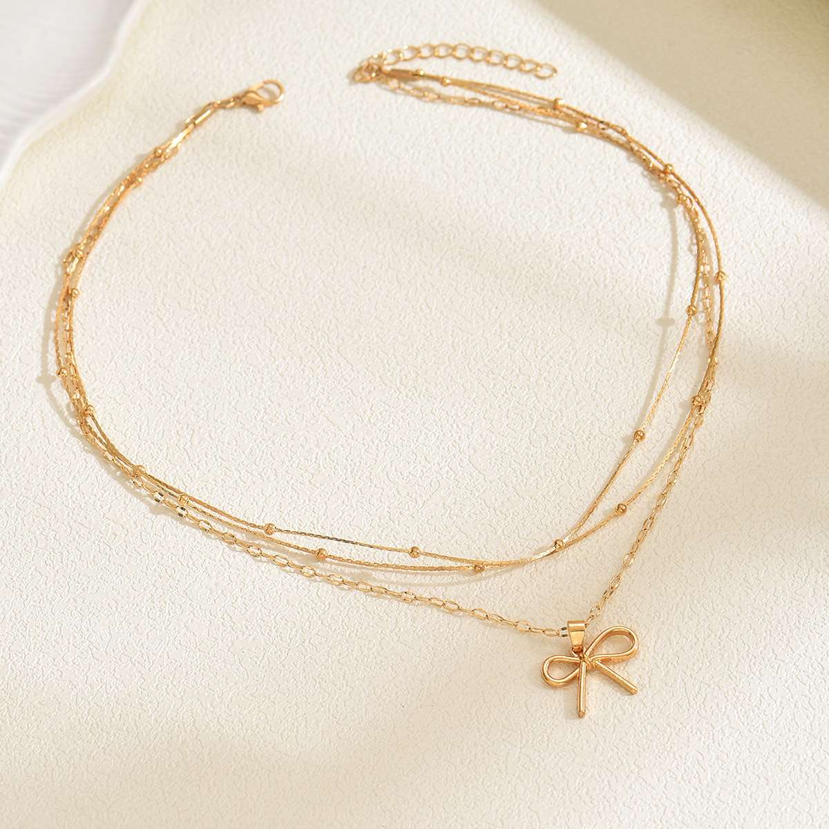 Elegant Gold Bow Pendant Necklace with Layered Chains image 0